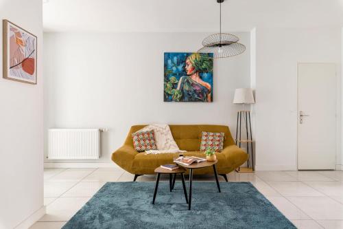 un salon avec un canapé et une table dans l'établissement Beige hospitalité - Capucine - Floral charmant chaleureux wifi Netflix, à Saint-Étienne