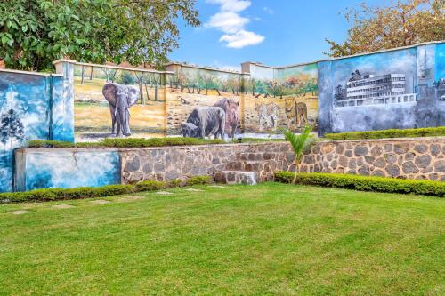 a mural of elephants on the side of a wall at Protea Hotel by Marriott Blantyre Ryalls in Blantyre
