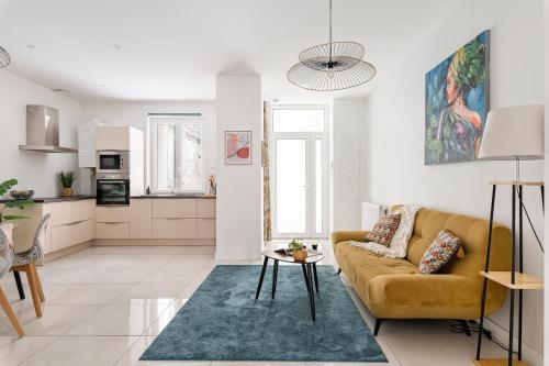 un salon avec un canapé et une table dans l'établissement Beige hospitalité - Capucine - Floral charmant chaleureux wifi Netflix, à Saint-Étienne