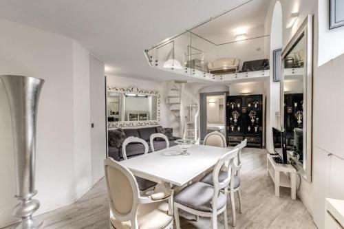 a dining room with a white table and chairs at Elegant flat in the Historic Rome near Colosseum! in Rome