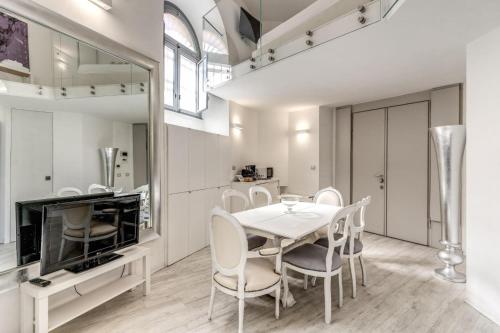 a dining room with a table and chairs and a mirror at Elegant flat in the Historic Rome near Colosseum! in Rome