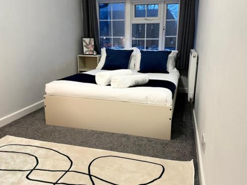 a bedroom with a bed with blue pillows and a window at Large House for 21 - Nottingham City in Nottingham