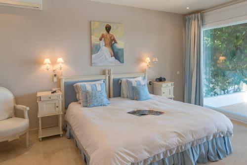 a bedroom with a bed with a painting on the wall at Villa Índigo in Benalup Casas Viejas