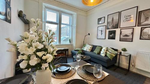 a living room with a couch and a table at Bright and spacious apartment near Glasgow in Dalmuir