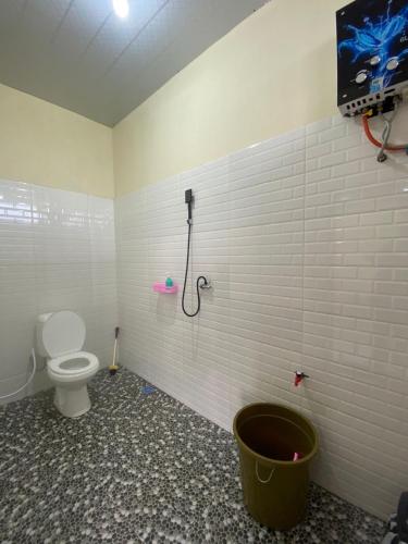 a bathroom with a toilet and a shower at Agriya Lubis 2 room in Diyeng
