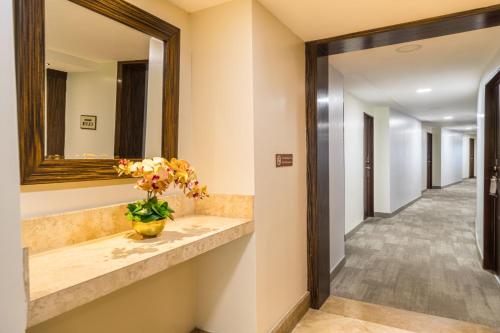 a hallway with a mirror and a vase with flowers at Sheraton Guayaquil in Guayaquil