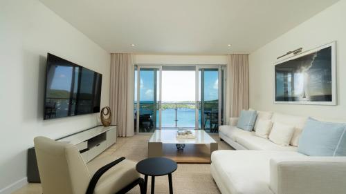 a living room with a white couch and a table at Premium Ocean View Condo - Amethyst in Hog Island