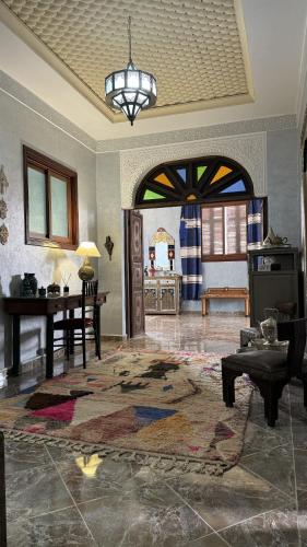 a living room with an archway and a room with a table at Dar Yamna Maison d'Hôtes in El Gouassem