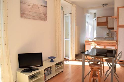 Il comprend un salon doté d'une télévision, d'une table et d'une cuisine. dans l'établissement Appartement VUE SUR MER de chaque pièce, exposé au Sud au centre de TREBEURDEN Réf - 666, à Trébeurden
