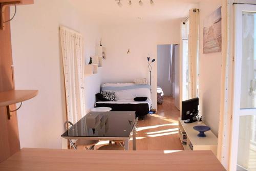 un salon avec une table et une télévision dans l'établissement Appartement VUE SUR MER de chaque pièce, exposé au Sud au centre de TREBEURDEN Réf - 666, à Trébeurden