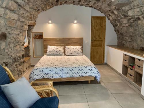Un dormitorio con una cama y una pared de piedra. en Mas de la Giralde - Gites, en Payzac