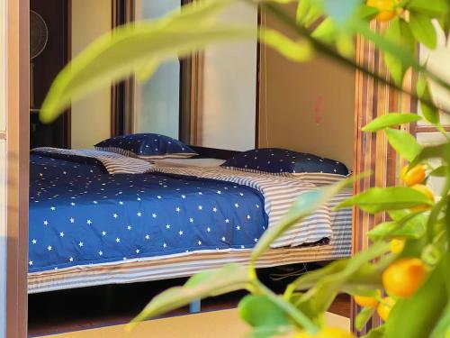 a bedroom with a bed with blue and white pillows at House near Shinjuku with parking & courtyard in Tokyo