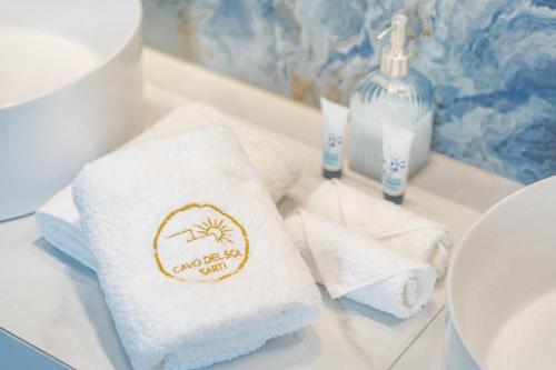 a bathroom with towels on a counter next to a sink at Cavo del Sol in Sarti
