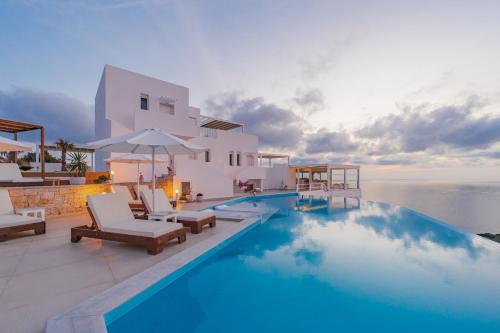 a villa with a swimming pool in front of the ocean at Cavo del Sol in Sarti