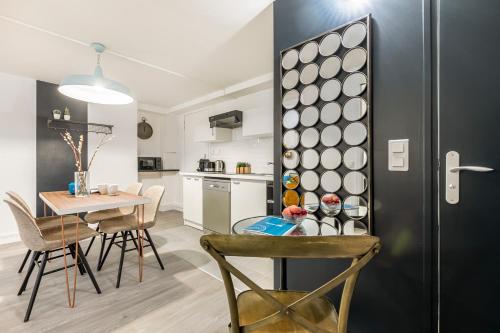 une cuisine et une salle à manger avec une table et des chaises dans l'établissement Sweett- Aboukir I, à Paris