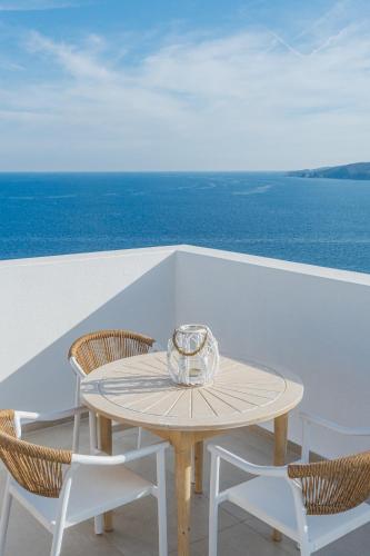 a table and chairs on a balcony with the ocean at Cavo del Sol in Sarti