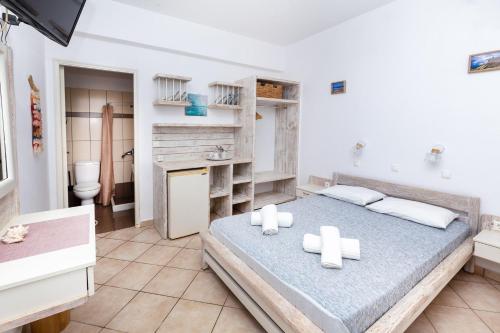 a bedroom with a bed and a bathroom at Harama Hotel Schinousa in Skhoinoussa