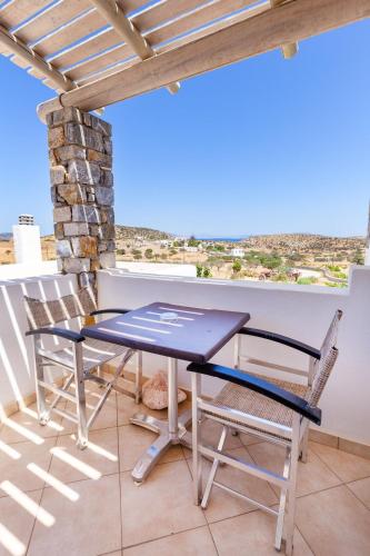 a table and chairs on the balcony of a house at Harama Hotel Schinousa in Skhoinoussa