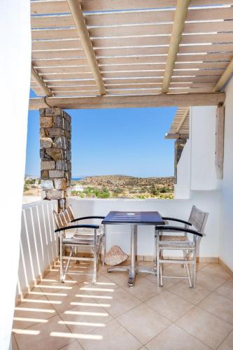 a patio with a table and chairs on a balcony at Harama Hotel Schinousa in Skhoinoussa