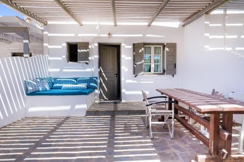 a patio with a wooden table and a bench at Harama Hotel Schinousa in Skhoinoussa