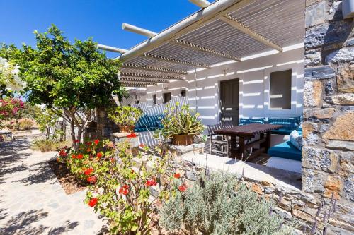 a patio with a table and some flowers at Harama Hotel Schinousa in Skhoinoussa