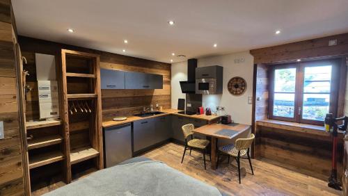 a room with a kitchen and a table with chairs at Un Brin Cosy in Névache