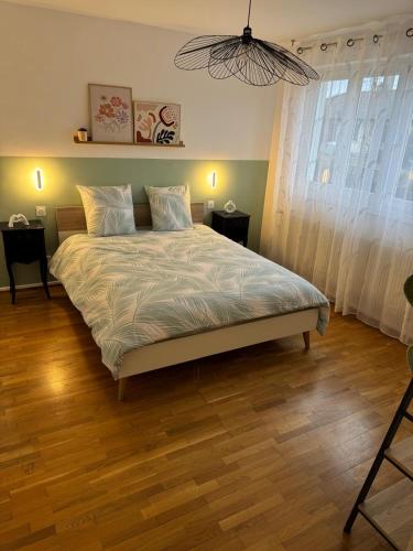 une chambre avec un grand lit avec un plancher en bois dans l'établissement Maison des chênes, à Bavilliers