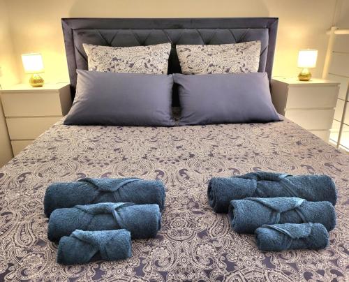 - un grand lit avec 2 oreillers bleus dans l'établissement Golden Royal - Studio Haut de Gamme, à Lyon