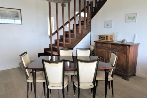 une salle à manger avec une table et des chaises et un escalier dans l'établissement Maison VUE MER avec jardin à 800m de la plage à TREBEURDEN REF-683, à Trébeurden