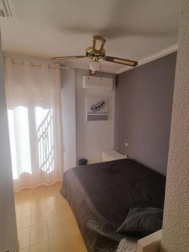 a bedroom with a bed and a ceiling fan at Bungalow Monover Playa in Santa Pola