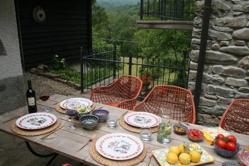 a wooden table with plates and bowls of fruit on it at B&B Casale delle farfalle in Tornolo