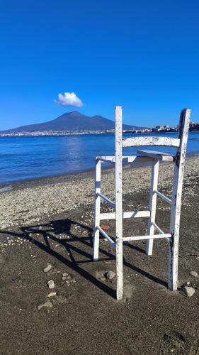 a chair sitting on the beach near the water at Mira Capri in Castellammare di Stabia