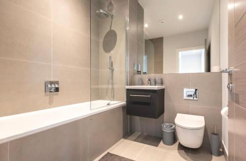 a bathroom with a shower and a toilet and a sink at Apartment Thirty Three Staines Upon Thames - Free Parking - Heathrow - Thorpe Park - Studio in Staines