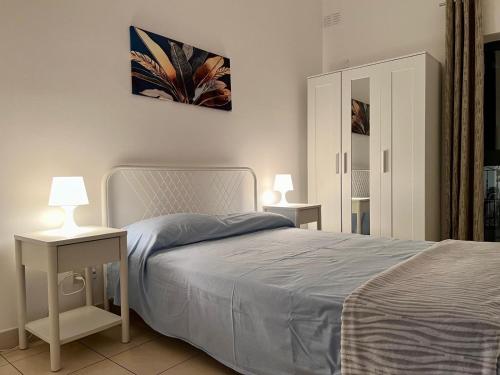a bedroom with a bed and two tables with lamps at Centrally Located Gzira in Il-Gżira