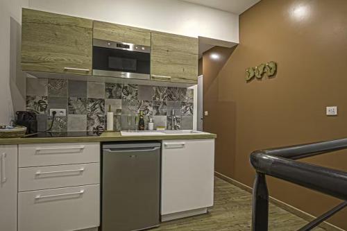 une cuisine avec un évier et un micro-ondes dans l'établissement Love room balnéo sauna Le Havre, au Havre