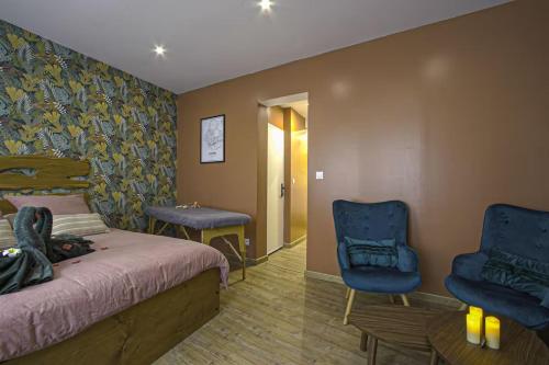 - une chambre avec un lit et deux chaises bleues dans l'établissement Love room balnéo sauna Le Havre, au Havre