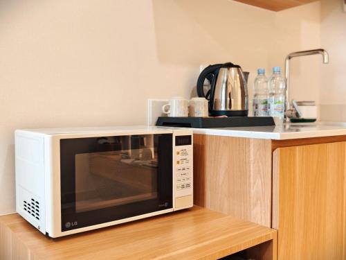 a microwave oven sitting on top of a kitchen counter at Studio Sea View Apartment at Gold Coast PIK by MYsweethome in Jakarta