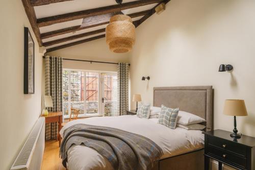 a bedroom with a large bed and a window at Half Way House, Clappersgate, sleeps 8 in Ambleside