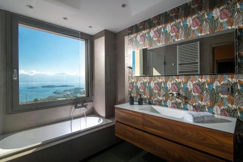 a bathroom with a tub and a large window at Villa Serenity Cove in Agios Nikolaos