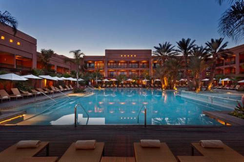 a large swimming pool in front of a building at Pickalbatros Hôtel Du Golf - Adults Friendly 16 Years Plus- All-Inclusive in Marrakech
