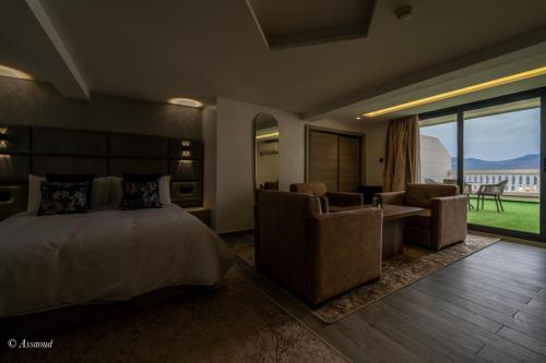 a bedroom with a bed and a desk and chairs at Luxury Chaouen in Chefchaouene