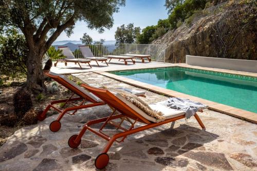 - une piscine avec 2 chaises longues à côté de la piscine dans l'établissement Villa Mimosa, climatisée avec Piscine et Vue Mer pour 10 personnes à La Londe-Les-Maures, à La Londe-les-Maures
