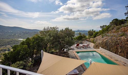 une villa avec une piscine au sommet d'une montagne dans l'établissement Villa Mimosa, climatisée avec Piscine et Vue Mer pour 10 personnes à La Londe-Les-Maures, à La Londe-les-Maures
