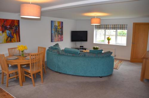 a living room with a blue couch and a table at pottergate mews in Helmsley