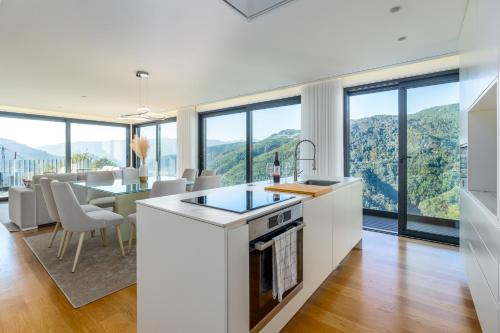 a kitchen and dining room with a view of the mountains at Waterfall View in Paradise in Louredo
