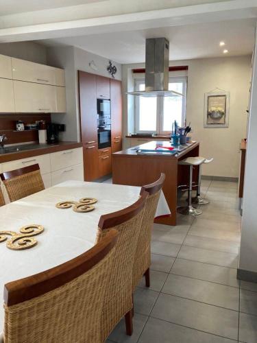 une cuisine avec une table et des chaises blanches ainsi qu'une cuisine avec un comptoir dans l'établissement Maison Kersavanou, à Rosporden