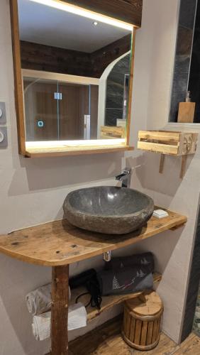 a bathroom with a sink on a wooden shelf at Un Brin Cosy in Névache