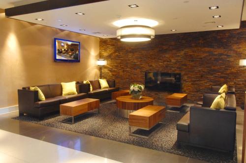 a lobby with couches and a tv and a fireplace at Stamford Bridge Hotel London in London