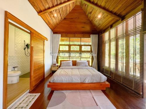 Un dormitorio con una cama grande y una ventana. en วิลล่า ป่าเหมี้ยง Villa Pa Miang, en Ban Pa Miang