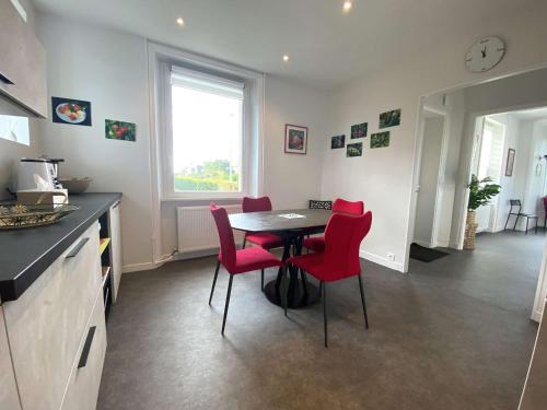 une cuisine avec une table et des chaises rouges dans une pièce dans l'établissement Maison bretonne à 200m de la mer à proximité de l'Ile Renote à Trégastel - Ref 76, à Trégastel